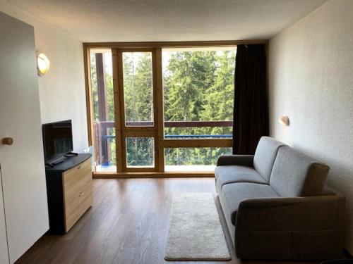 un salon avec un canapé et une grande fenêtre dans l'établissement Résidence Bellecote - Studio 2 personnes pied des pistes MAE-2045, à Arc 1800