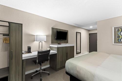 a hotel room with a bed and a desk with a computer at Quality Inn Oskaloosa in Oskaloosa