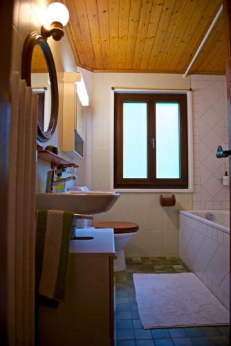 a bathroom with a sink and a toilet and a window at Chalet familiale spacieux - près de Villars in Huémoz