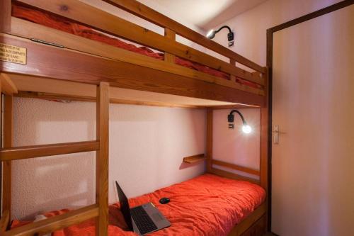 a bedroom with two bunk beds with a laptop on it at Résidence Gardiole 4 - Appartement spacieux · Proche des pistes · Wifi gratuit & proche des Grands Bains MAE-0234 in Le Monêtier-les-Bains
