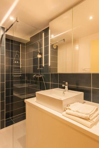 une salle de bain avec un lavabo blanc et une douche dans l'établissement Résidence Gardiole 4 - Appartement spacieux · Proche des pistes · Wifi gratuit & proche des Grands Bains MAE-0234, au Monêtier-les-Bains