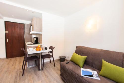 un salon avec un canapé et une table dans l'établissement Résidence Bois Des Coqs - Studio rénové avec casier à skis · Cœur de station · Parking extérieur MAE-0264, à Champcella