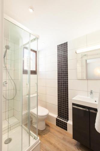 une salle de bain avec une douche en verre et des toilettes dans l'établissement Résidence Bois Des Coqs - Studio rénové avec casier à skis · Cœur de station · Parking extérieur MAE-0264, à Champcella