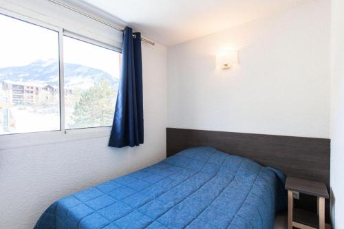 une chambre avec un lit bleu et une fenêtre dans l'établissement Résidence Relais De La Guisane - Appartement rénové · Proche des remontées mécaniques · Coin nuit MAE-0274, à Briançon
