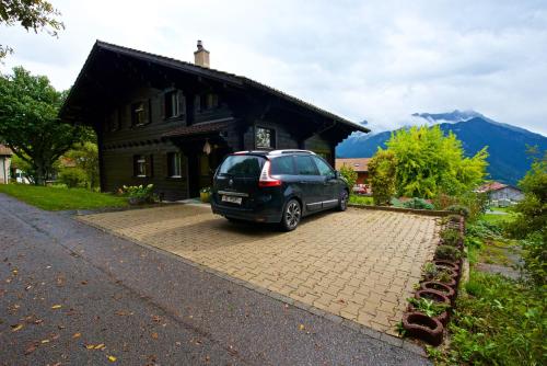 a small car parked in front of a house at Chalet familiale spacieux - près de Villars in Huémoz