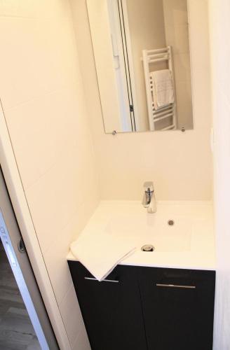 une salle de bain avec un lavabo et un miroir dans l'établissement Résidence Relais De La Guisane - Appartement lumineux · Proche des remontées mécaniques · coin montagne MAE-0334, à Briançon