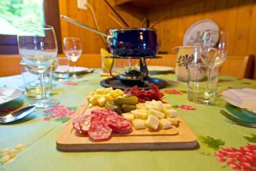 a table with meat and cheese on a cutting board at Chalet familiale spacieux - près de Villars in Huémoz