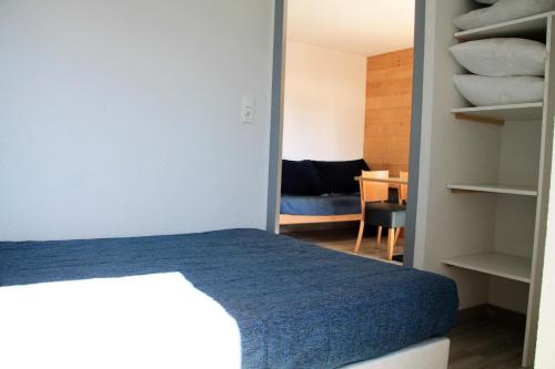 - une chambre avec un lit bleu et un bureau dans l'établissement Résidence Relais De La Guisane - Appartement chaleureux & rénové · Proche des remontées mécaniques MAE-0354, à Briançon