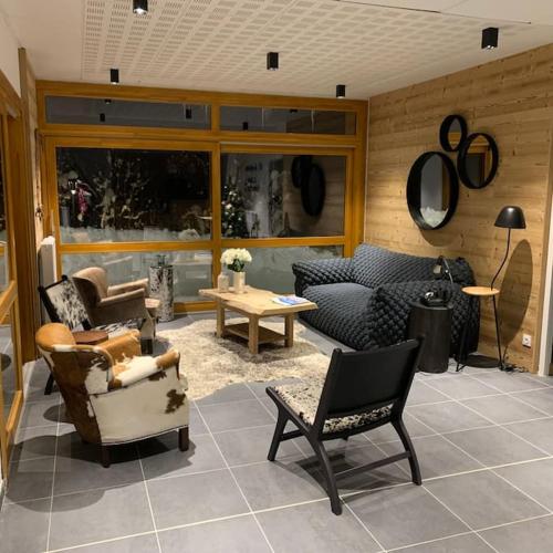 un salon avec des chaises, un canapé et une table dans l'établissement New apartment in chalet Vaujany, Classified 4 Etoiles, à Vaujany