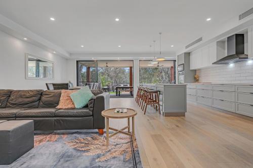 a living room and kitchen with a couch and a table at Marina Palms - Your Luxury Escape in Torrumbarry