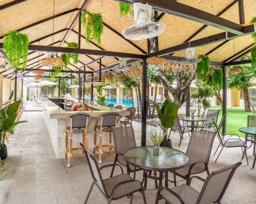 an outdoor patio with tables and chairs and a bar at Mermaid Beach Resort - 100m to Beach, Saltwater Pool & BeerGarden in Jomtien Beach