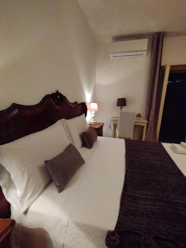 a bedroom with a large white bed with brown pillows at Petalo Rosso b&b in Lenola