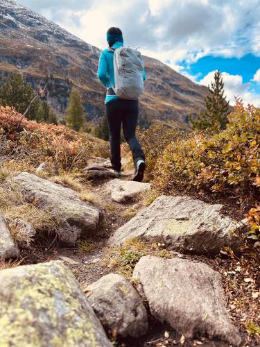 a person with a backpack walking on a mountain trail at Urlaub am Bauernhof in Karrösten