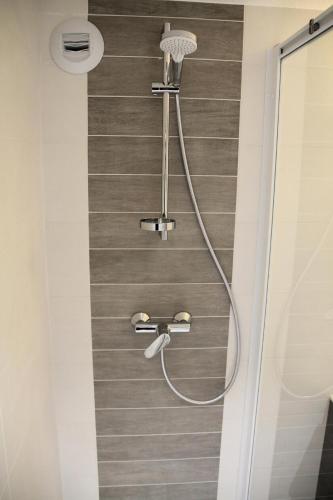 une douche avec pommeau de douche dans une salle de bain dans l'établissement Résidence Signal Du Prorel - Appartement rénové · Au pied des remontées mécaniques · Wifi gratuit MAE-0514, à Briançon