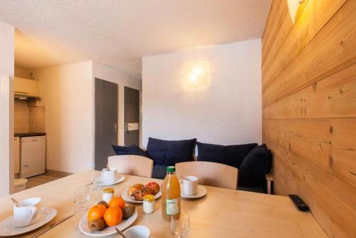 - une table à manger avec des fruits et des bouteilles dans l'établissement Résidence Relais De La Guisane - Appartement rénové · Proche des pistes · Casier à skis MAE-0544, à Briançon