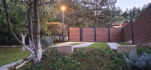 a garden with a fence and a wooden gate at Pyramid Holiday House in Visoko