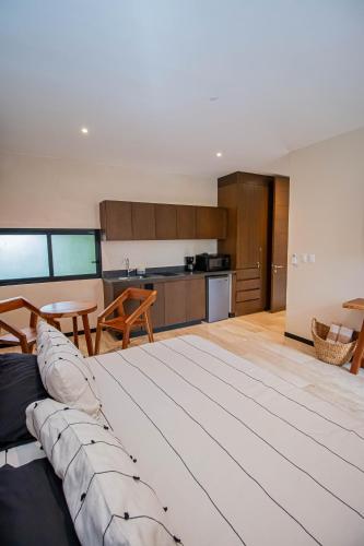 a living room with a couch and a kitchen at Ophelia Experience in Tulum