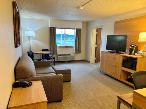 a living room with a couch and a flat screen tv at Holiday Inn Spearfish-Convention Center by IHG in Spearfish