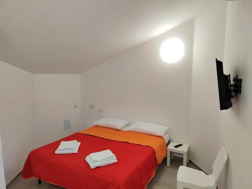a white room with a bed with a red blanket at Casa Borgo Antico Cavallaro in Gaggi