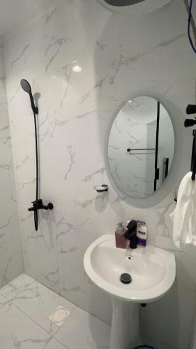 a white bathroom with a sink and a mirror at Modern studio Self entry in Riyadh