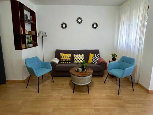 - un salon avec un canapé et deux fauteuils bleus dans l'établissement Apartamento Primavera Centro, à Ronda