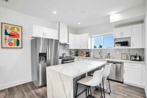 a kitchen with white cabinets and a white counter top at Luxe Townhouse Near Downtown LA in Los Angeles