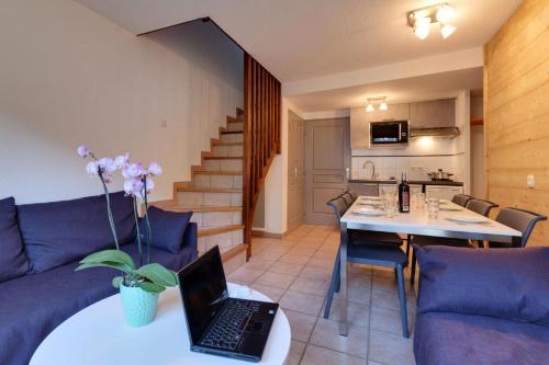 un salon avec un canapé et un ordinateur portable sur une table dans l'établissement Chalets Jardin Alpin - Chalet mitoyen triplex tout confort · Accès pistes par navette · WIFI gratuit · Terrasse · Vue dégagée MAE-4764, à La Salle Les Alpes