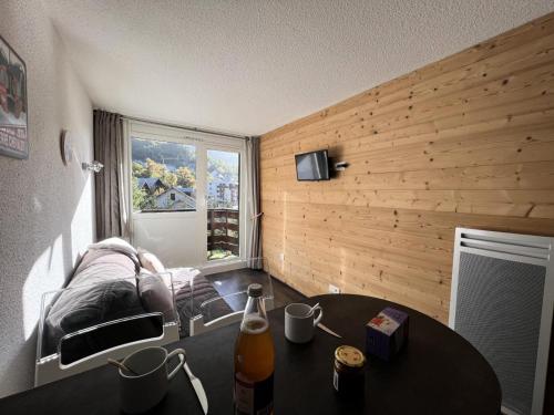 a living room with a table and a couch at Résidence Les Melezes - Studio rénové avec parking extérieur · Accès pistes par navette MAE-1054 in Champcella