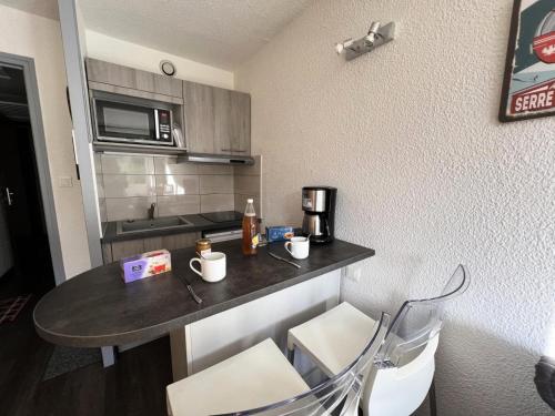 a small kitchen with a table in a room at Résidence Les Melezes - Studio rénové avec parking extérieur · Accès pistes par navette MAE-1054 in Champcella