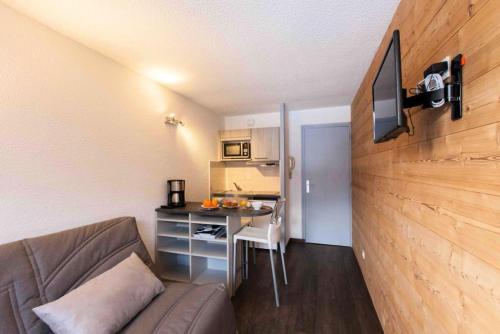 a living room with a couch and a desk in a room at Résidence Les Melezes - Studio rénové & chaleureux · Accès pistes par navettes · Parking extérieur MAE-1104 in Champcella