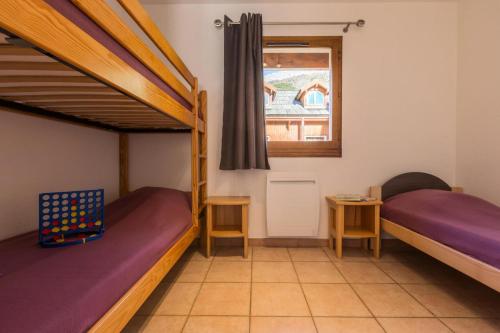 une chambre avec deux lits superposés et une fenêtre dans l'établissement Chalets Jardin Alpin - Chalet mitoyen duplex lumineux · Accès pistes par navette · Wifi gratuit · vue dégagée MAE-4794, à La Salle Les Alpes