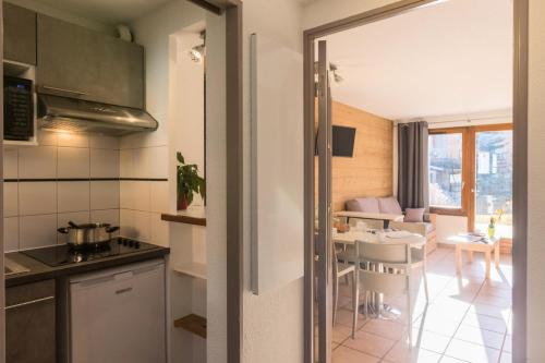 une cuisine et une salle à manger avec une table et des chaises dans l'établissement Chalets Jardin Alpin - Chalet mitoyen duplex rénové · Accès pistes par navette · Terrasse · WIFI gratuit · Vue dégagée MAE-4824, à La Salle Les Alpes