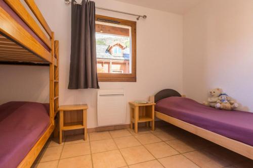 une chambre avec deux lits superposés et une fenêtre dans l'établissement Chalets Jardin Alpin - Chalet mitoyen lumineux en duplex · Accès pistes par navette · WIFI gratuit · Vue dégagée MAE-4874, à La Salle Les Alpes