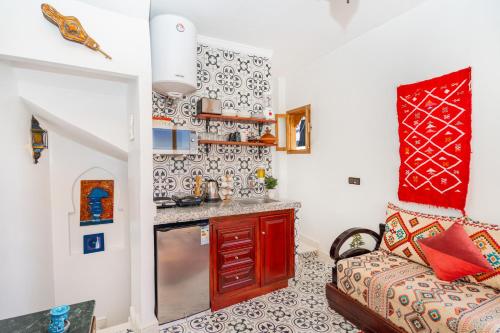 a living room with a couch and a kitchen at Dar baba Aziz La perle de la Médina in Tangier