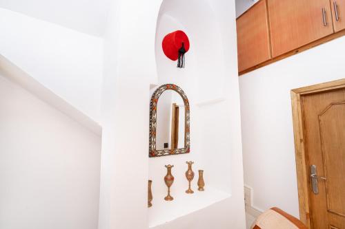 a hallway with a mirror and hooks on the wall at Dar baba Aziz La perle de la Médina in Tangier