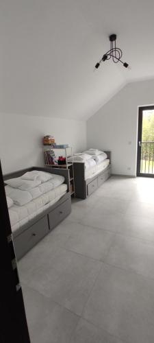 a bedroom with two beds and a ceiling fan at Nowa Osada in Łącko