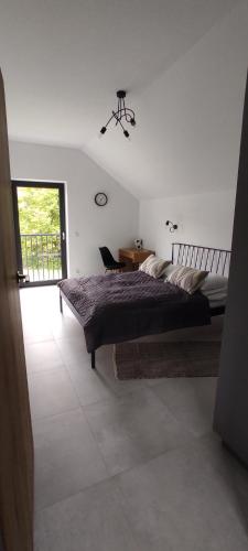 a bedroom with a bed and a desk and a window at Nowa Osada in Łącko