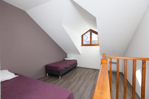 Cette chambre mansardée comprend un lit et une fenêtre. dans l'établissement Chalets Jardin Alpin - Chalet mitoyen spacieux · Accès pistes par navette · Wifi gratuit MAE-4964, à La Salle Les Alpes