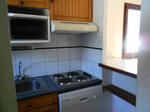 Il comprend une petite cuisine équipée d'une cuisinière et d'un évier. dans l'établissement Chalets Jardin Alpin - Chalet mitoyen triplex · Accès pistes par navette · WIFI gratuit MAE-4984, à La Salle Les Alpes