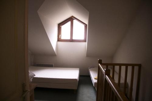 une petite chambre avec un lit et une fenêtre dans l'établissement Chalets Jardin Alpin - Chalet mitoyen triplex · Accès pistes par navette · WIFI gratuit MAE-4984, à La Salle Les Alpes