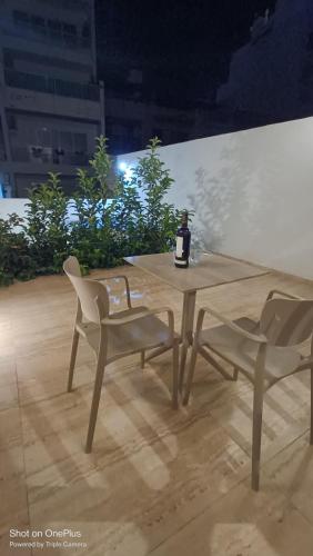 a bottle of wine sitting on a table with two chairs at Sea Esta Guest House in Mellieħa
