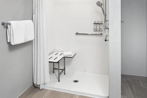 a white bathroom with a shower and a sink at Holiday Inn Express Cleveland Airport - Brook Park by IHG in Brook Park