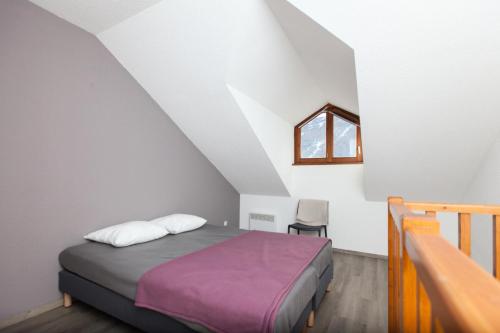 - une chambre avec un lit doté d'une couverture violette et d'une fenêtre dans l'établissement Chalets Jardin Alpin - Chalet mitoyen spacieux en duplex · Accès pistes par navette · Wifi gratuit MAE-5024, à La Salle Les Alpes