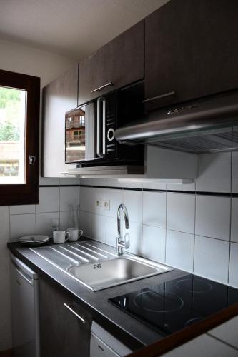 une cuisine avec un évier et un plan de travail dans l'établissement Chalets Jardin Alpin - Chalet mitoyen duplex · Accès pistes par navette · Wifi gratuit & Terrasse MAE-5034, à La Salle Les Alpes