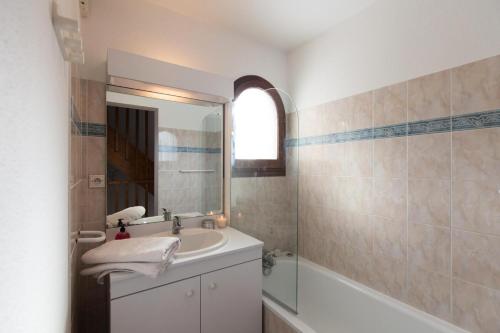 une salle de bain avec un lavabo, un miroir et une baignoire dans l'établissement Chalets Jardin Alpin - Chalet mitoyen entièrement rénové · Accès pistes par navette · Terrasse & wifi gratuit MAE-5044, à La Salle Les Alpes