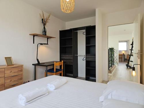 - une chambre avec un lit blanc, un bureau et une table dans l'établissement La villa Lumière, à Orgères