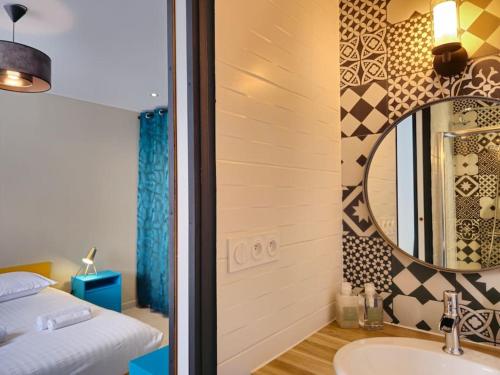 une salle de bain avec un lit, un lavabo et un miroir dans l'établissement La villa Lumière, à Orgères