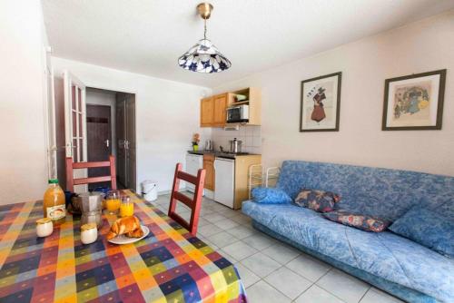 un salon avec un canapé bleu et une table dans l'établissement Résidence Jardin Alpin Edelweiss - Studio confortable · Accès pistes par navette · Casier à skis privatif MAE-5064, à La Salle Les Alpes