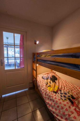 - une chambre avec un lit superposé avec un animal rembourré dans l'établissement Résidence Jardin Alpin Edelweiss - Studio confortable · Accès pistes par navette · Casier à skis privatif MAE-5064, à La Salle Les Alpes