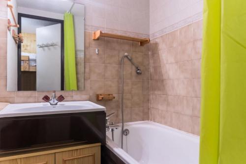 une salle de bain avec un lavabo, une baignoire et un miroir dans l'établissement Résidence Bouquetins A - Studio mezzanine de 35m2 pour 6 personnes MAE-7804, à Montvalezan